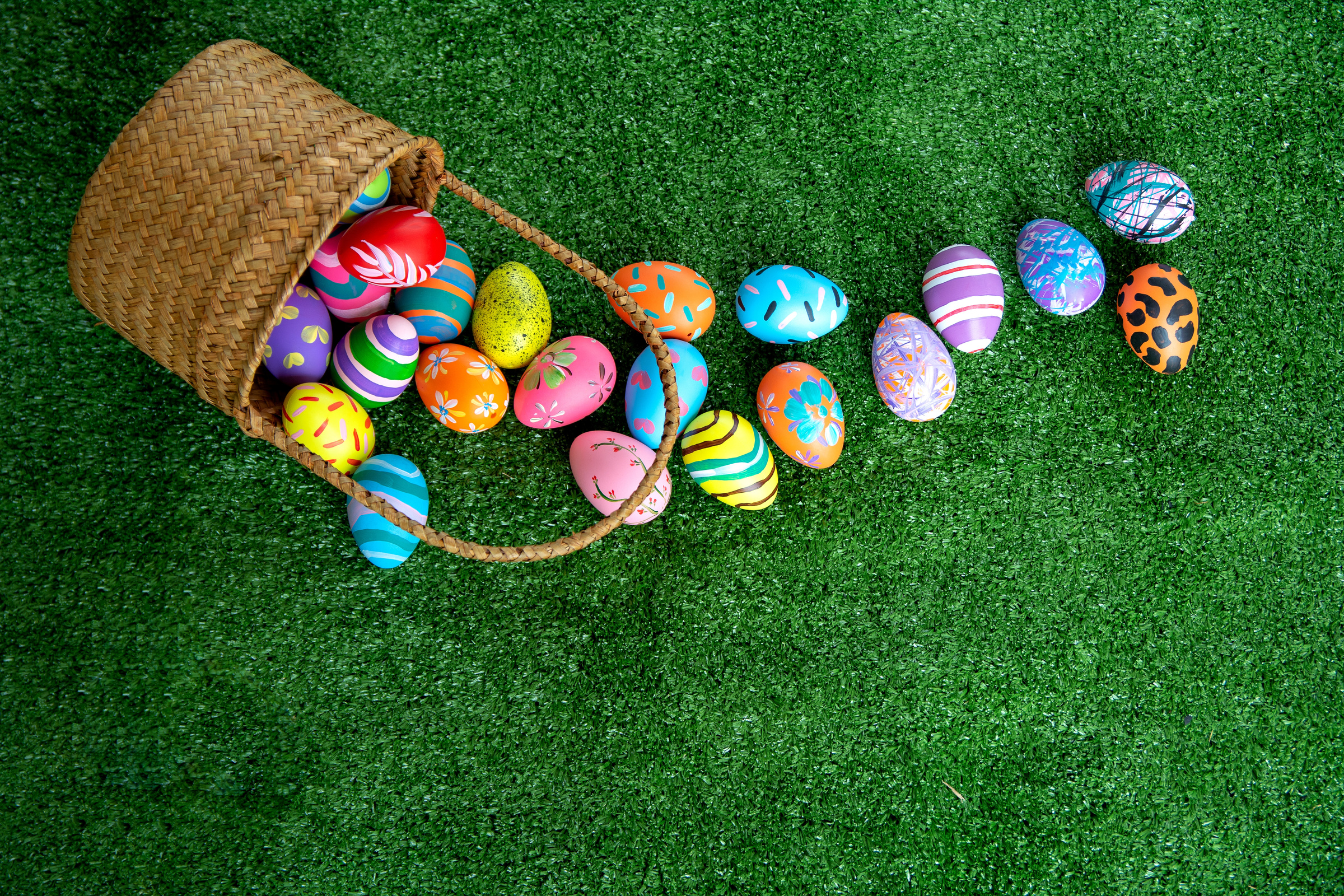Easter background with Easter eggs in basket. Easter eggs on grass background